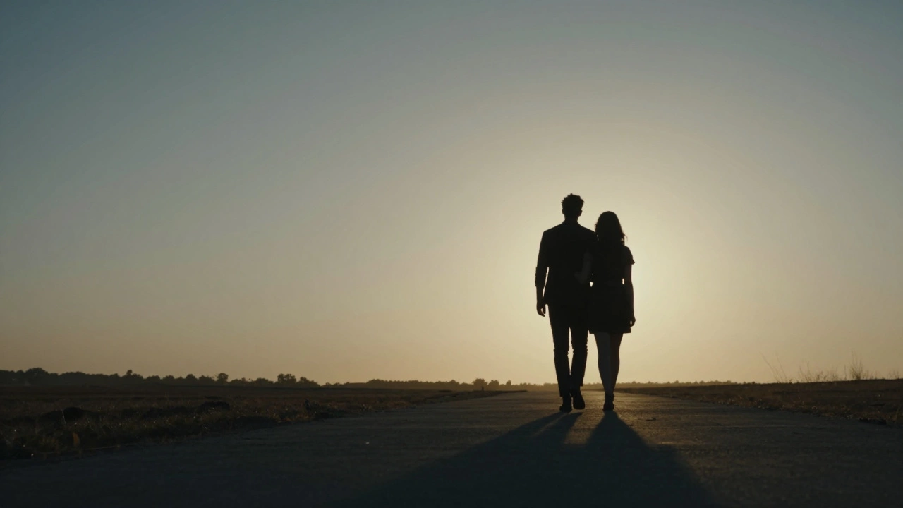 Silhouettes of a couple walking together towards a bright horizon
